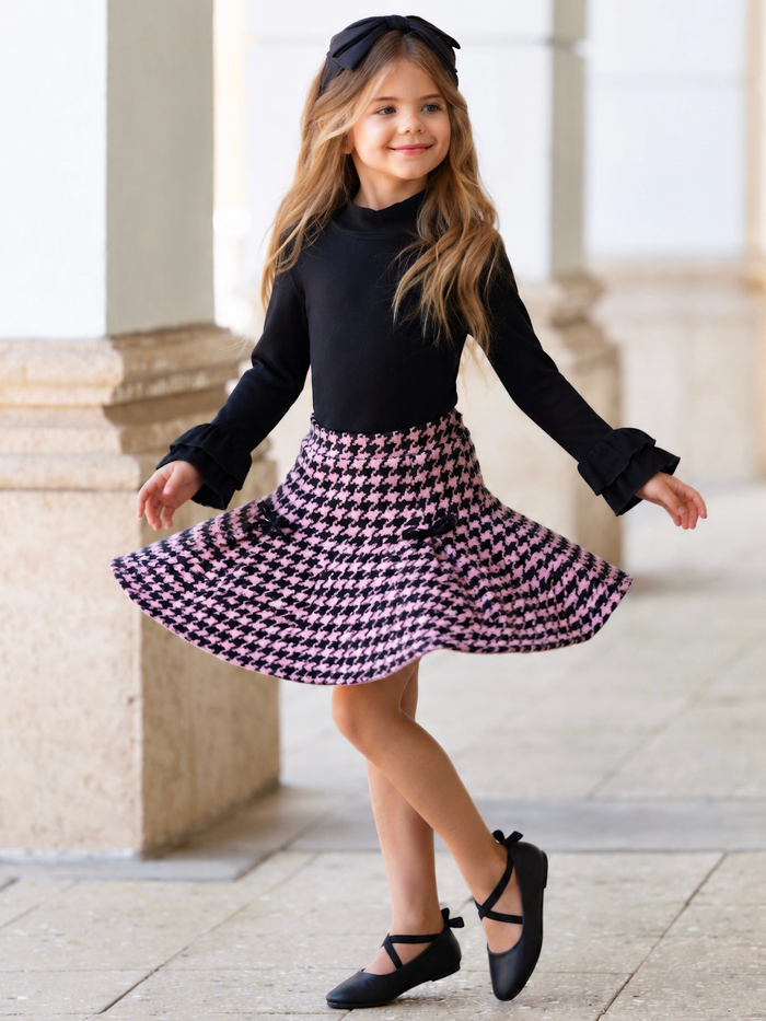 Girl wearing a black knit top with a pink houndstooth skirt set for fall special occasions