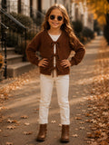 Girl wearing a cocoa brown knit cardigan with bow tie closures.